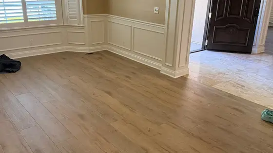 Wide-plank LVP flooring installation in a Rancho Cordova dining room with white wainscoting