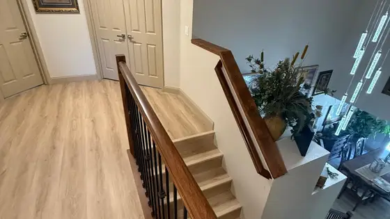 Upstairs hallway in a Sacramento home with light oak plank flooring and a new stair railing