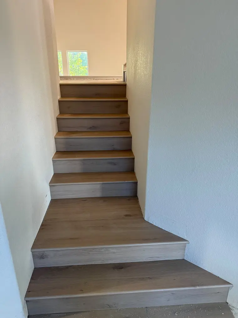 After: Bare OSB winder staircase finished with wide oak-look plank treads